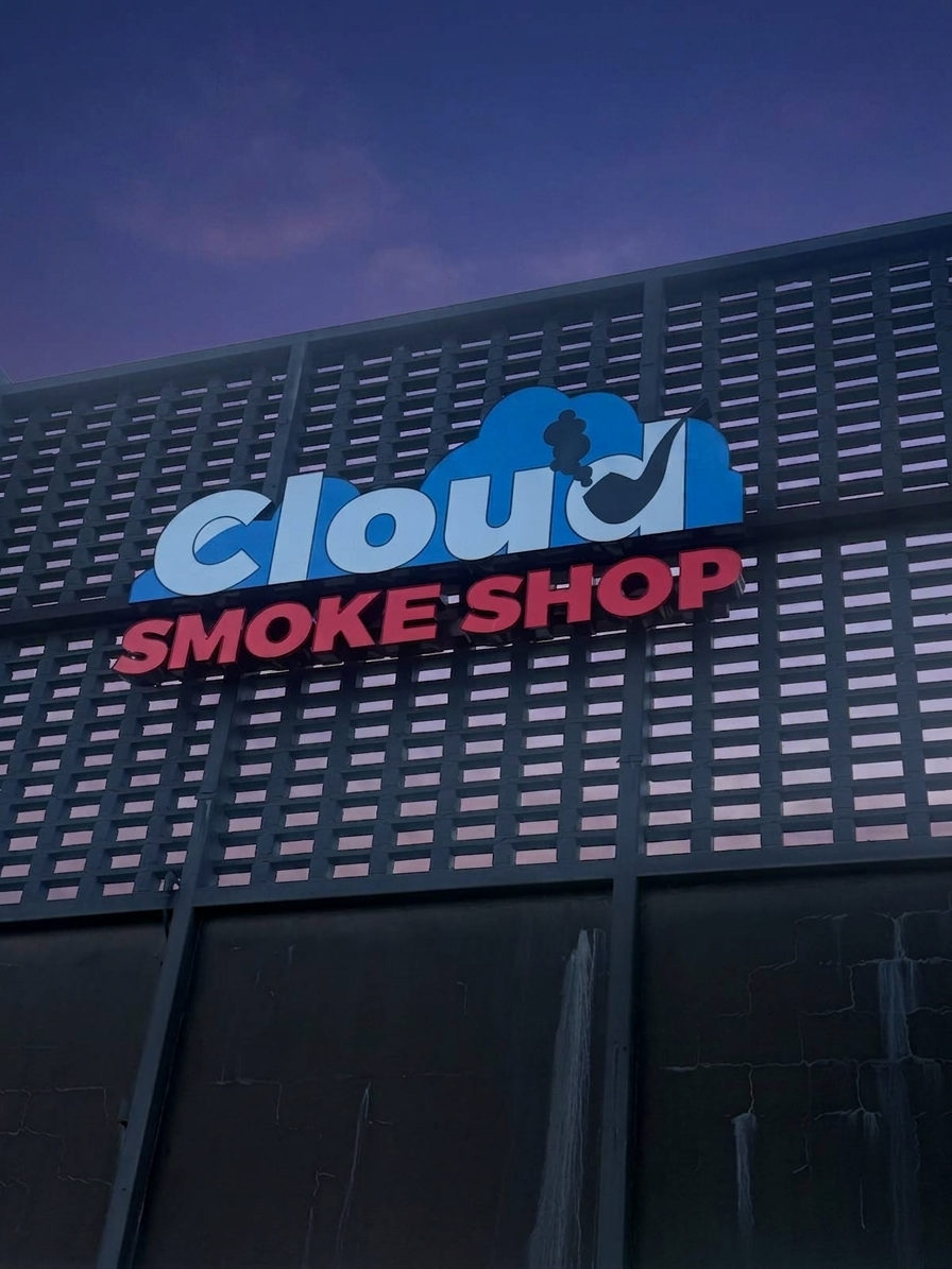 Cloud Smoke Shop's illuminated storefront sign at dusk on Tennessee Street, near FSU.